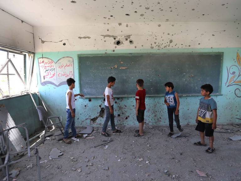 Niños palestinos observan la destrucción de su escuela tras los ataques sobre Gaza
