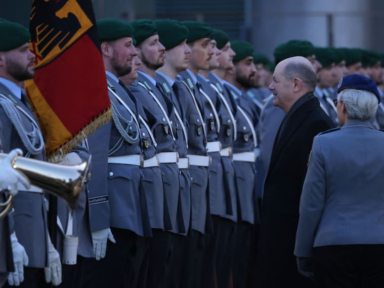 El canciller de Alemania, Olaf Scholz, saluda a un grupo de soldados formados en la ciudad de Berlín.