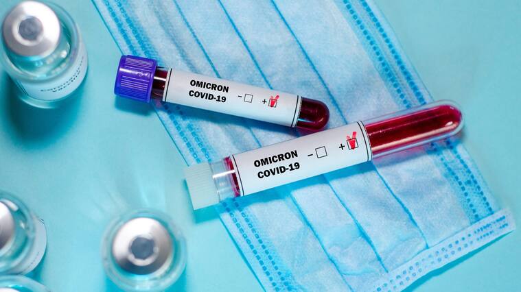 Test tube with positive Omicron COVID-19 test blood sample and vaccine bottle in the medical laboratory.
