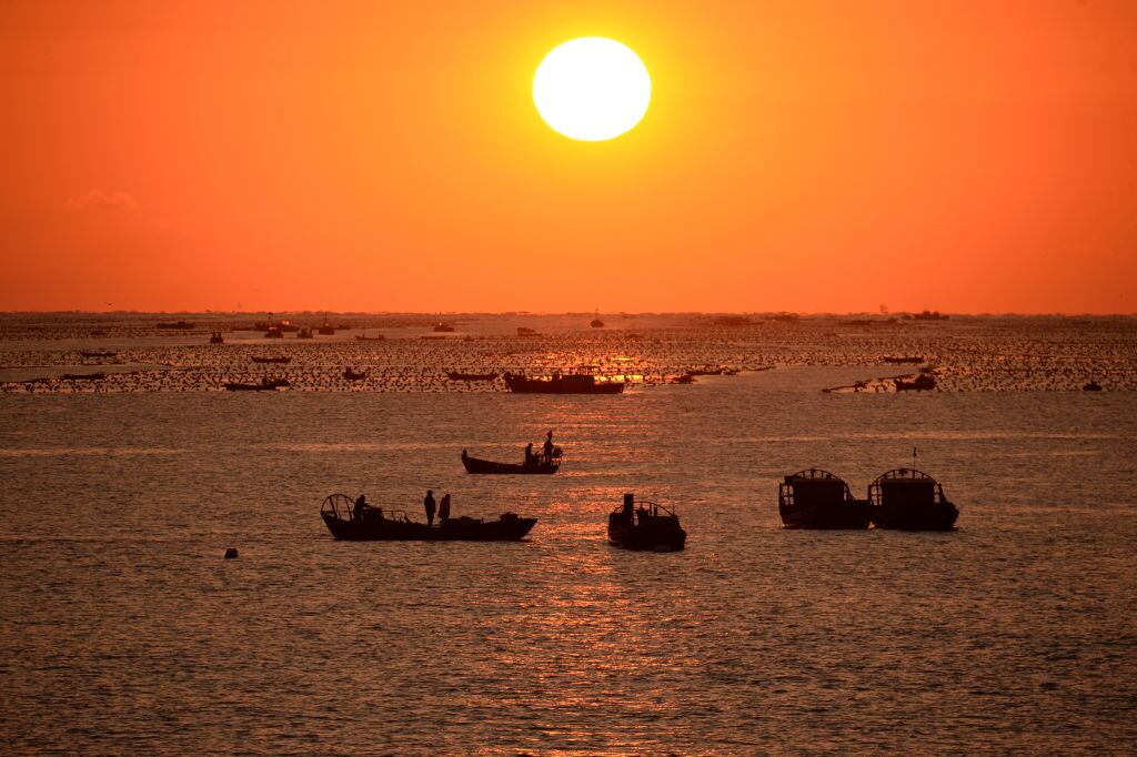 Barcos en China salen a pescar al elevarse el Sol