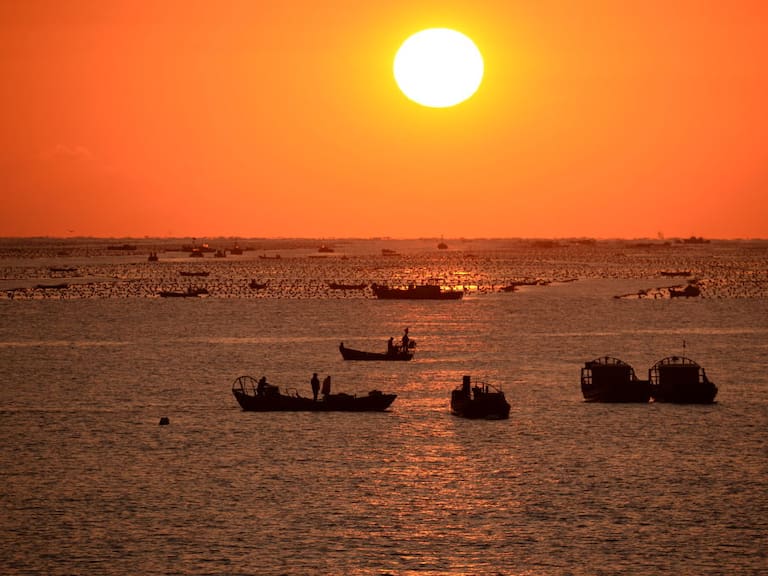 Barcos en China salen a pescar al elevarse el Sol