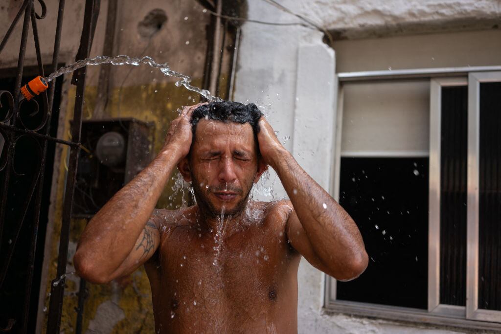 Hombre recibe agua en la calle ante el calor extremo que se vive en Brasil
