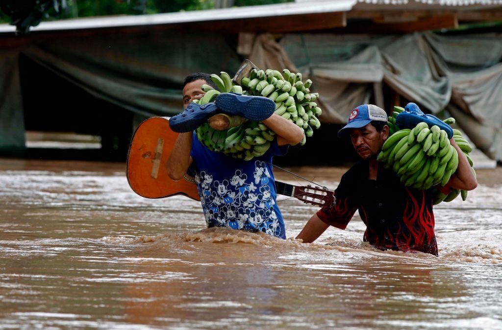 Personas intentan salvar alimentos en medio de las inundaciones en Centroamérica