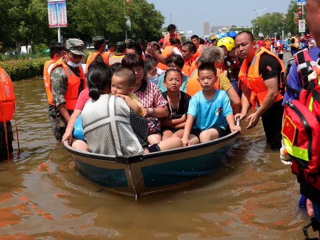 Rescatistas trasladan a personas afectadas por las inundaciones en Weihui