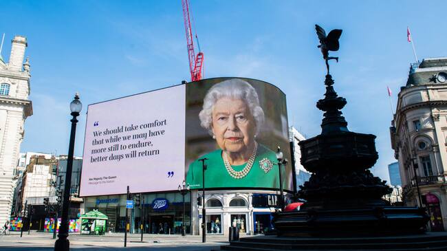 LONDON, ENGLAND - APRIL 10: An image of Queen Elizabeth II and quotes from her broadcast to the nation in relation to the coronavirus epidemic are displayed on screens in Piccadilly Circus on April 10, 2020 in London, England. (Photo by Samir Hussein/WireImage,)