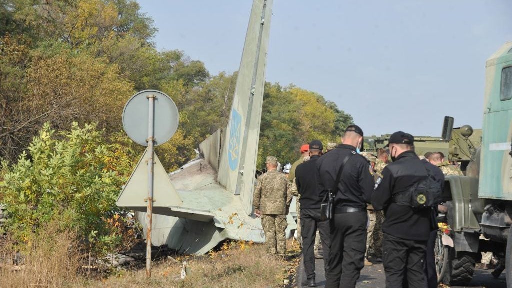 TOPSHOT - Military and experts work on the place of the Antonov-26 transport aircraft crash at Chuhuiv military air base around 30 kilometers southeast of Kharkiv on September 26, 2020. - 23 people including military cadets were killed when a Ukranian air force plane crashed near Kharkiv in the east of the country. The Antonov-26 transport plane was carrying 20 cadets and seven crew when it crashed late on September 25 two kilometres (about one mile) from the Chuguiv military air base near the city of Kharkiv. (Photo by SERGEY BOBOK / AFP) (Photo by SERGEY BOBOK/AFP via Getty Images)