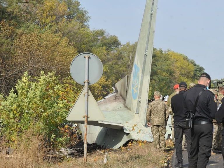 TOPSHOT - Military and experts work on the place of the Antonov-26 transport aircraft crash at Chuhuiv military air base around 30 kilometers southeast of Kharkiv on September 26, 2020. - 23 people including military cadets were killed when a Ukranian air force plane crashed near Kharkiv in the east of the country. The Antonov-26 transport plane was carrying 20 cadets and seven crew when it crashed late on September 25 two kilometres (about one mile) from the Chuguiv military air base near the city of Kharkiv. (Photo by SERGEY BOBOK / AFP) (Photo by SERGEY BOBOK/AFP via Getty Images)