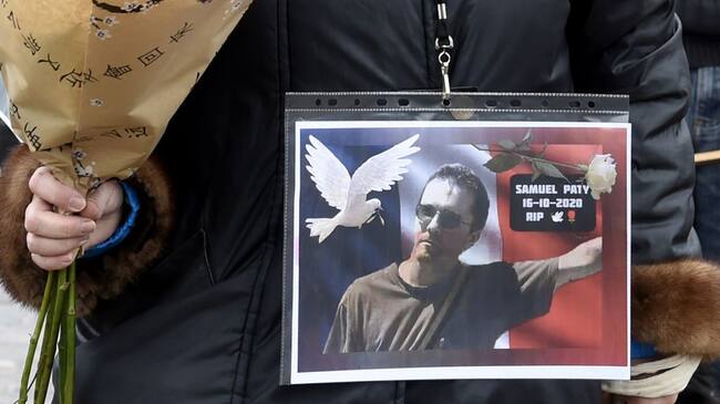 TOPSHOT - A woman holds a picture of Samuel Paty, Place de la Liberte in Lille on October 18, 2020, in homage to the history teacher, two days after he was beheaded by an attacker who was shot dead by policemen. - Thousands of people rally in Paris and other French cities on October 18 in a show of solidarity and defiance after a teacher was beheaded for showing pupils cartoons of the Prophet Mohammed. His murder in a Paris suburb on October 16 shocked the country and brought back memories of a wave of Islamist violence in 2015. (Photo by FRANCOIS LO PRESTI / AFP) (Photo by FRANCOIS LO PRESTI/AFP via Getty Images)