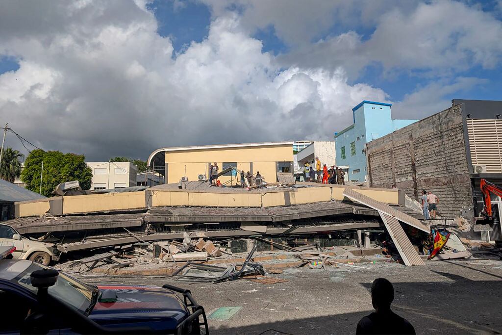 Rescatistas revisan bajo los escombros de un edificio colapsado en la capital Port Vila de Vanuatu, luego de recibir un terremoto de magnitud 7.3