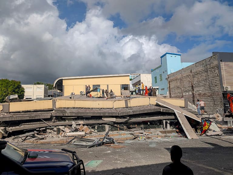 Rescatistas revisan bajo los escombros de un edificio colapsado en la capital Port Vila de Vanuatu, luego de recibir un terremoto de magnitud 7.3