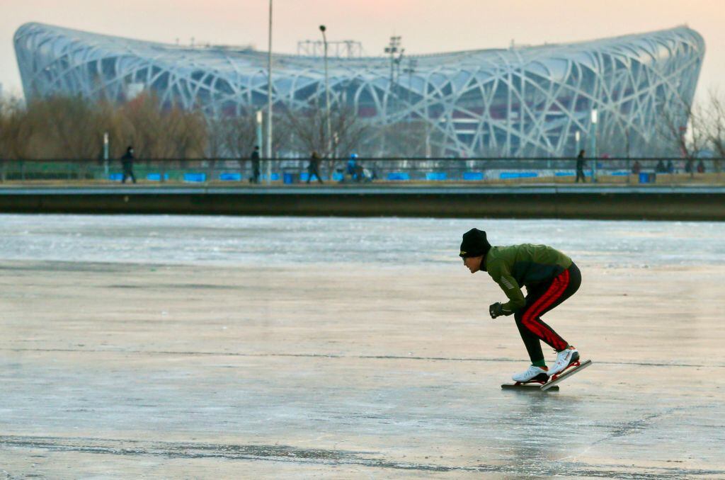 Un hombre patina en un canal ante el Estadio Nacional de Pekín