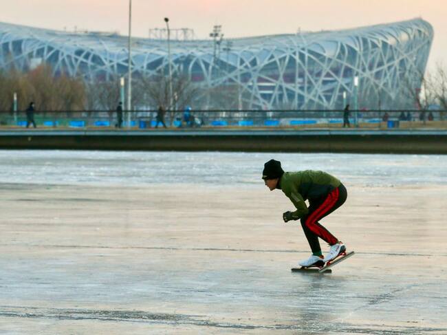 Un hombre patina en un canal ante el Estadio Nacional de Pekín