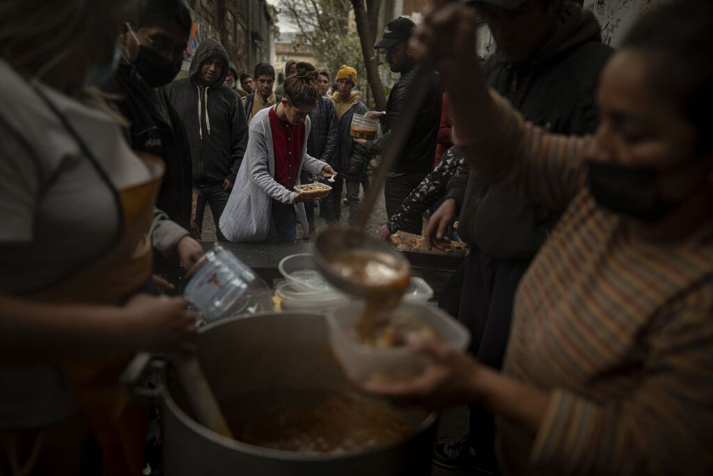 Un grupo de personas en situación de pobreza reciben alimentos en el comedor popular llamado la Casa del Pueblo en la ciudad de Buenos Aires.