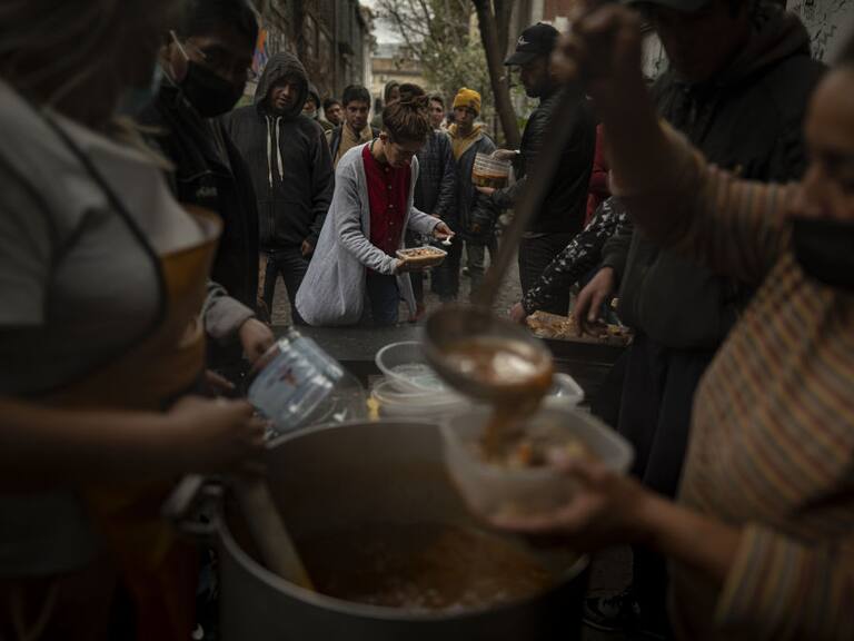 Un grupo de personas en situación de pobreza reciben alimentos en el comedor popular llamado la Casa del Pueblo en la ciudad de Buenos Aires.