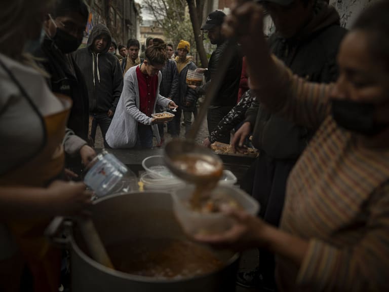 Un grupo de personas en situación de pobreza reciben alimentos en el comedor popular llamado la Casa del Pueblo en la ciudad de Buenos Aires.