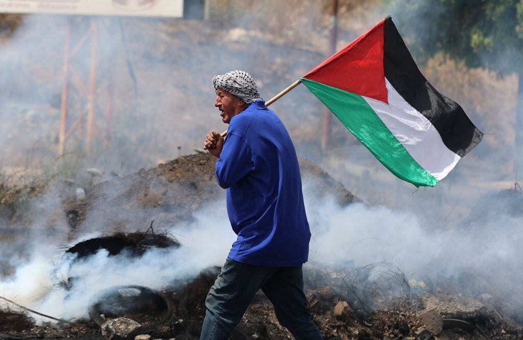 Manifestante palestino con la bandera en la ciudad de Nablus
