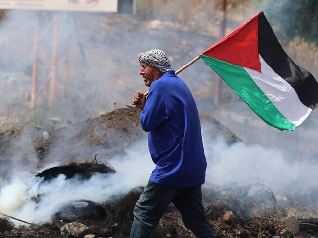 Manifestante palestino con la bandera en la ciudad de Nablus