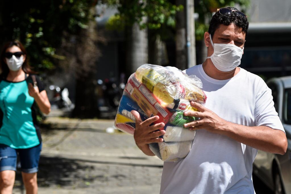 Un hombre recibe asistencia de un paquete de comida en Belo Horizonte