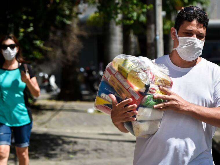 Un hombre recibe asistencia de un paquete de comida en Belo Horizonte
