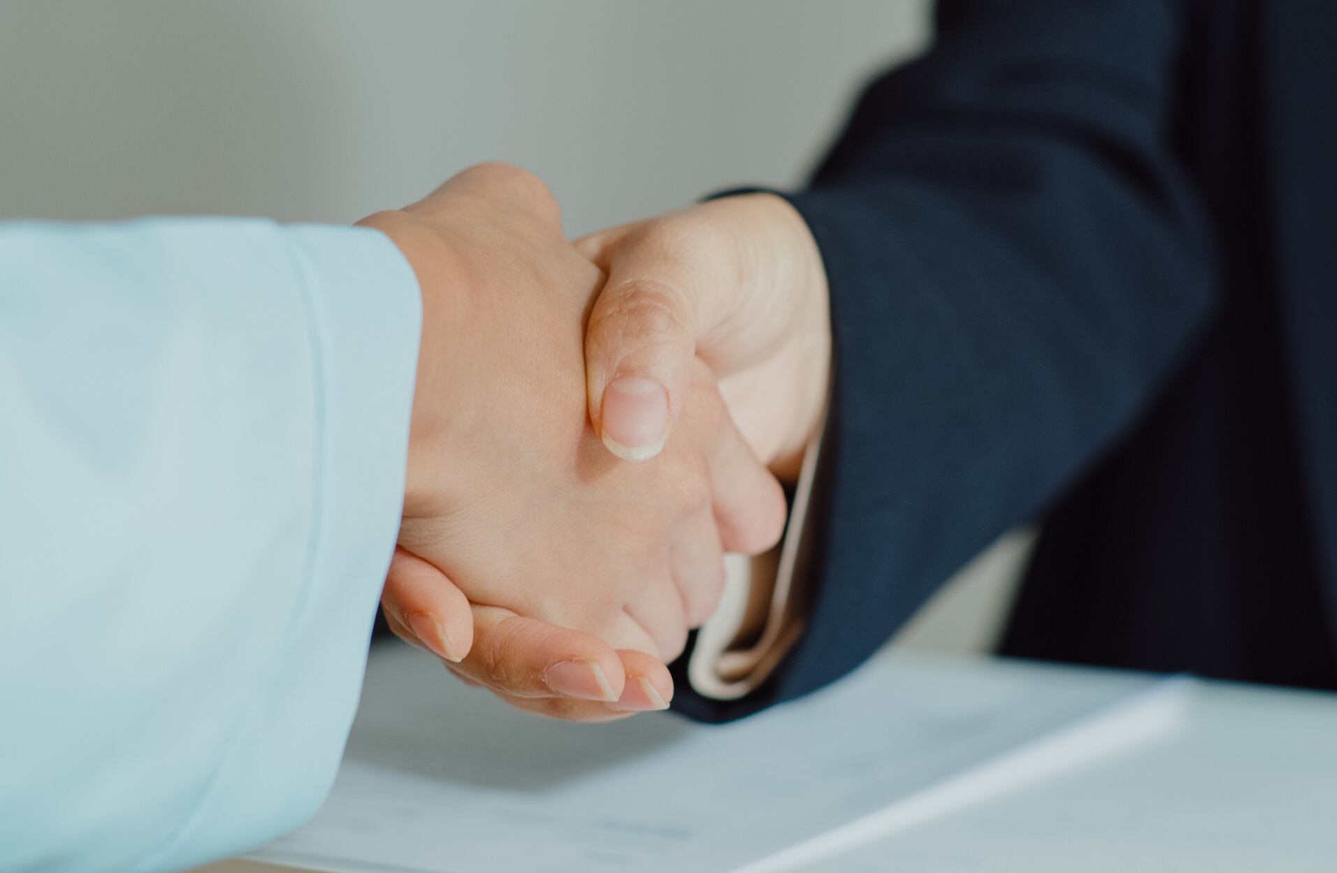 Closeup of young Asian woman pass job interview sit in front of HR manager and shake hands at office. Human resource, Recruitment agency concept.