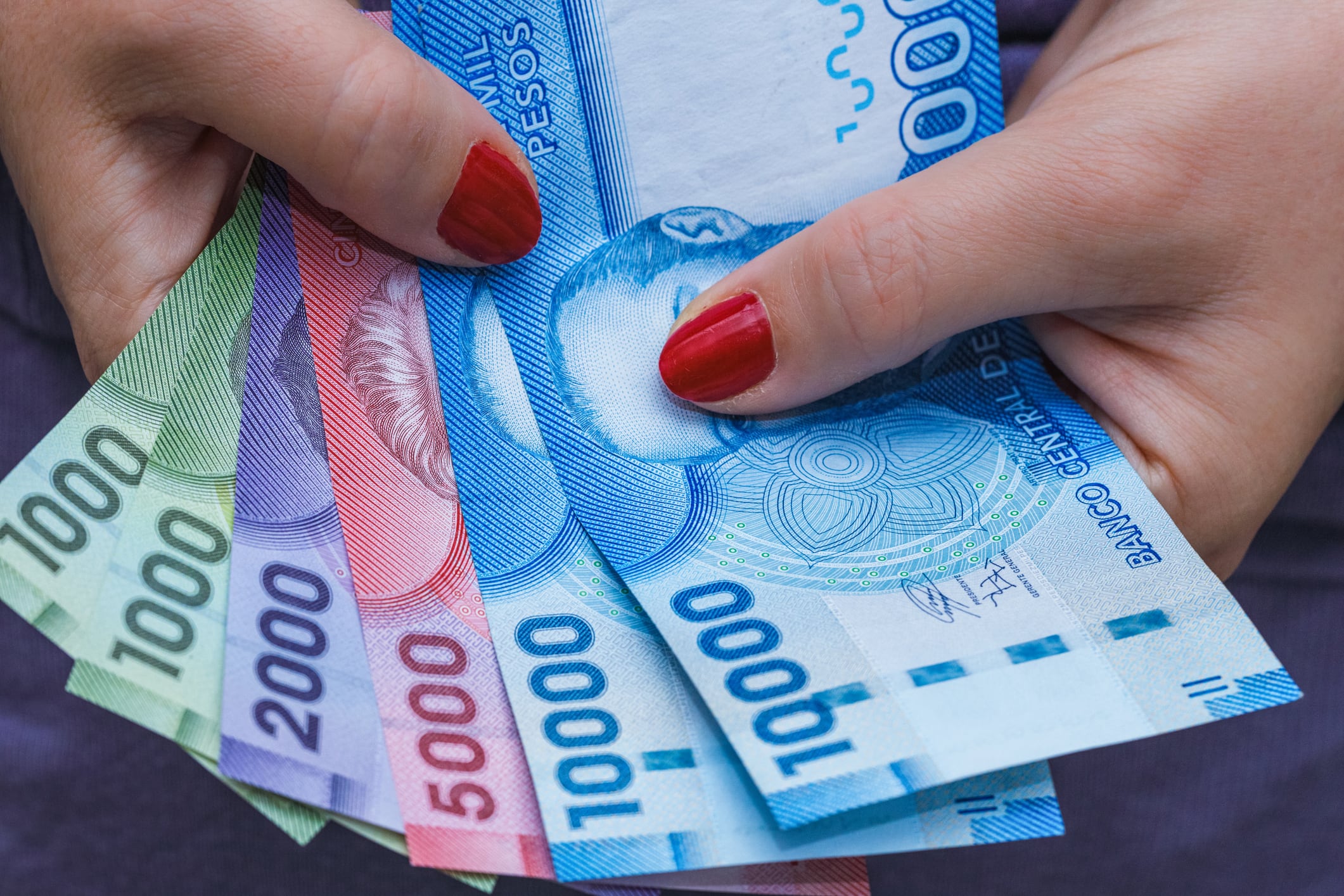 Chile currency, pesos, banknotes in a woman's hand