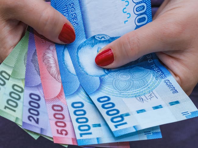 Chile currency, pesos, banknotes in a woman's hand