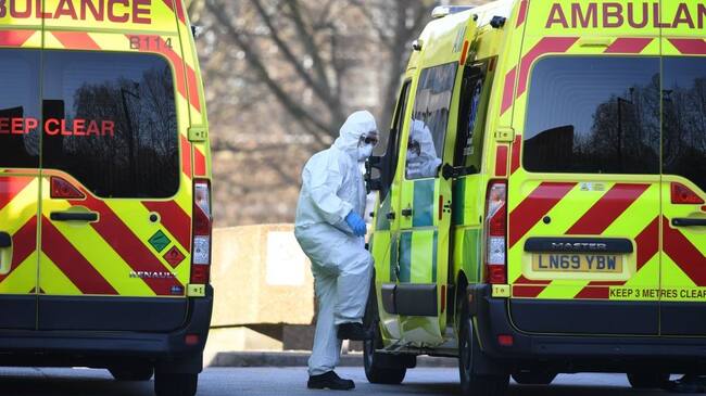 A member of the ambulance service wearing personal protective equipment is seen leading a patient (unseen) into an ambulance at St Thomas' Hospital in London on March 24, 2020. - Britain's leaders on Tuesday urged people to respect an unprecedented countrywide lockdown, saying that following advice to stay at home would stop people dying of coronavirus. (Photo by DANIEL LEAL-OLIVAS / AFP) (Photo by DANIEL LEAL-OLIVAS/AFP via Getty Images)