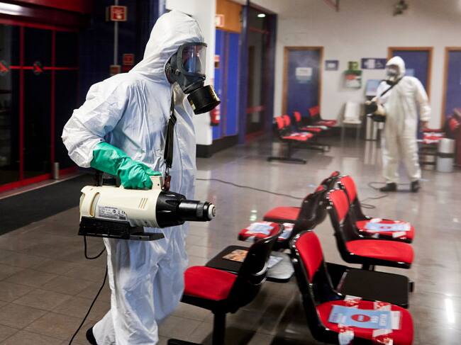 Trabajadores sanitizan un terminal de aeropuerto en Portugal
