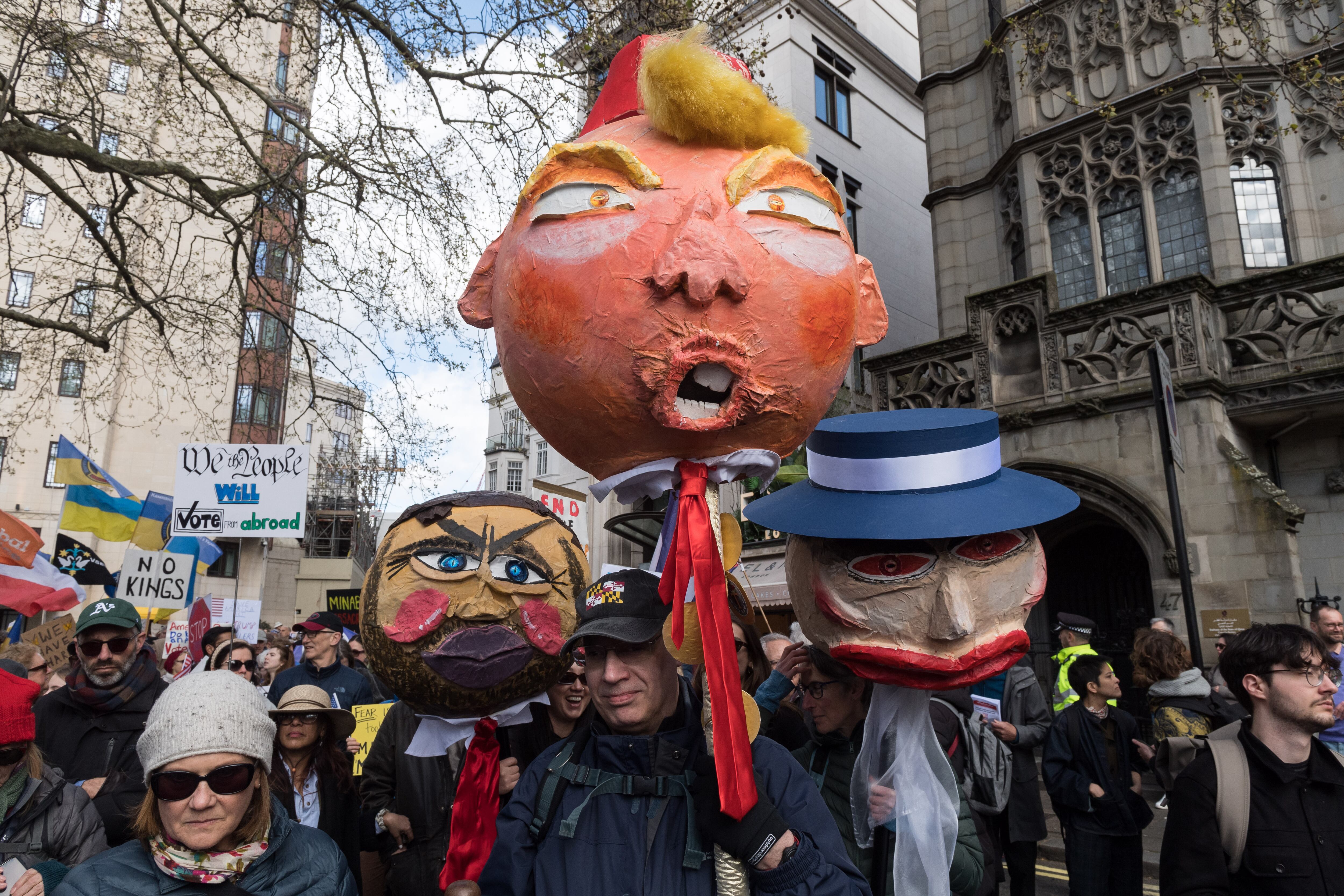 LONDON, UNITED KINGDOM - MARCH 28, 2026: Demonstrators hold papier mache heads depicting US Vice President JD Vance, US President Donald Trump and First Lady Melania Trump during a protest against Donald Trump administration's immigration enforcement tactics and the war in Iran ahead of Together Alliance March Against the Far Right in London, United Kingdom on March 28, 2026. The demonstration is part of a global day of action with events taking place at more than 3,000 locations, as US citizens and others protest against what the organisers desribe as authoritarian actions of the Trump adiministration. (Photo credit should read Wiktor Szymanowicz/Future Publishing via Getty Images)