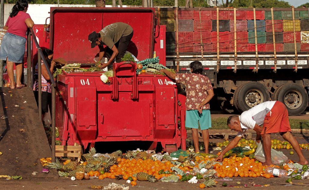 Personas buscan restos de frutas y verduras en un basurero en Belem