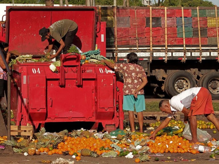 Personas buscan restos de frutas y verduras en un basurero en Belem
