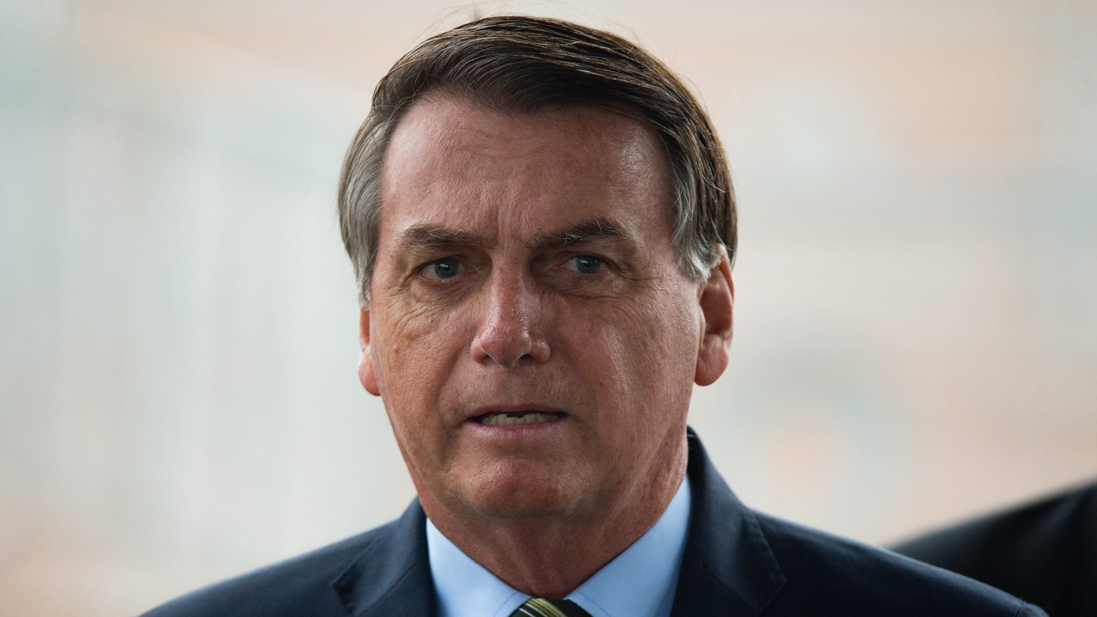 BRASILIA, BRAZIL - MARCH 25: Brazilian President Jair Bolsonaro looks on during a press conference amidst the coronavirus (COVID - 19) pandemic at the Palacio do Alvorada on March, 25, 2020 in Brasilia, Brazil. Bolsonaro recently defended the nation's return to normality and the end of social distancing and quarantine. According to the Ministry of health, as today, Brazil has 2271 confirmed cases infected with the coronavirus (COVID-19) and at least 47 recorded deceases.(Photo by Andressa Anholete / Getty Images)