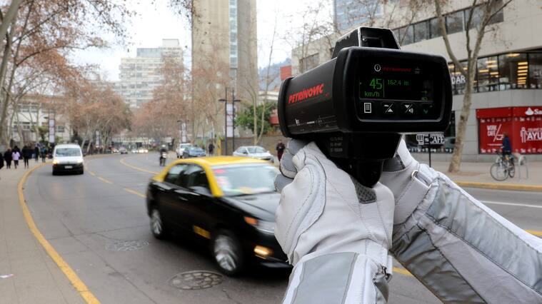 Carabinero fiscaliza la velocidad de los vehículos, tras una actividad realizada en el marco de la puesta en marcha de la ley de disminución de velocidad urbana