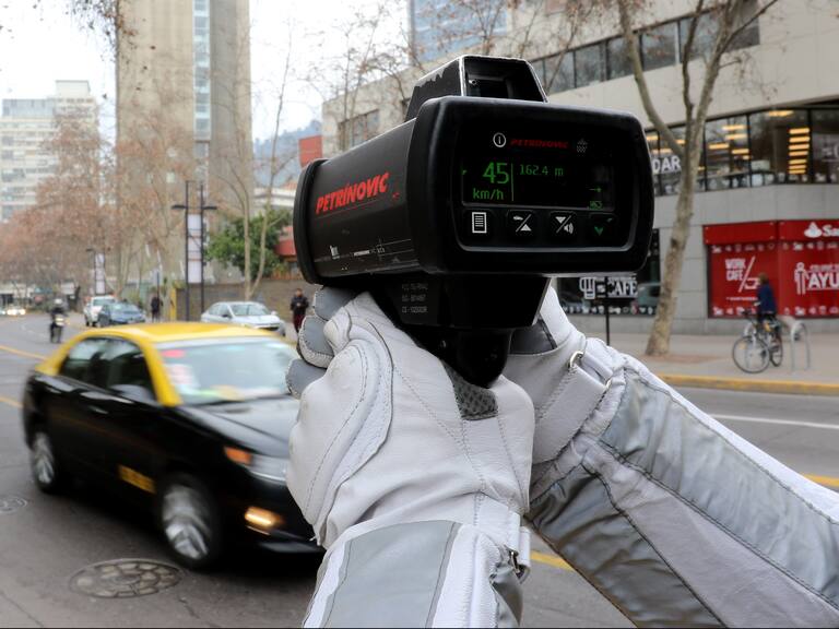 Carabinero fiscaliza la velocidad de los vehículos, tras una actividad realizada en el marco de la puesta en marcha de la ley de disminución de velocidad urbana