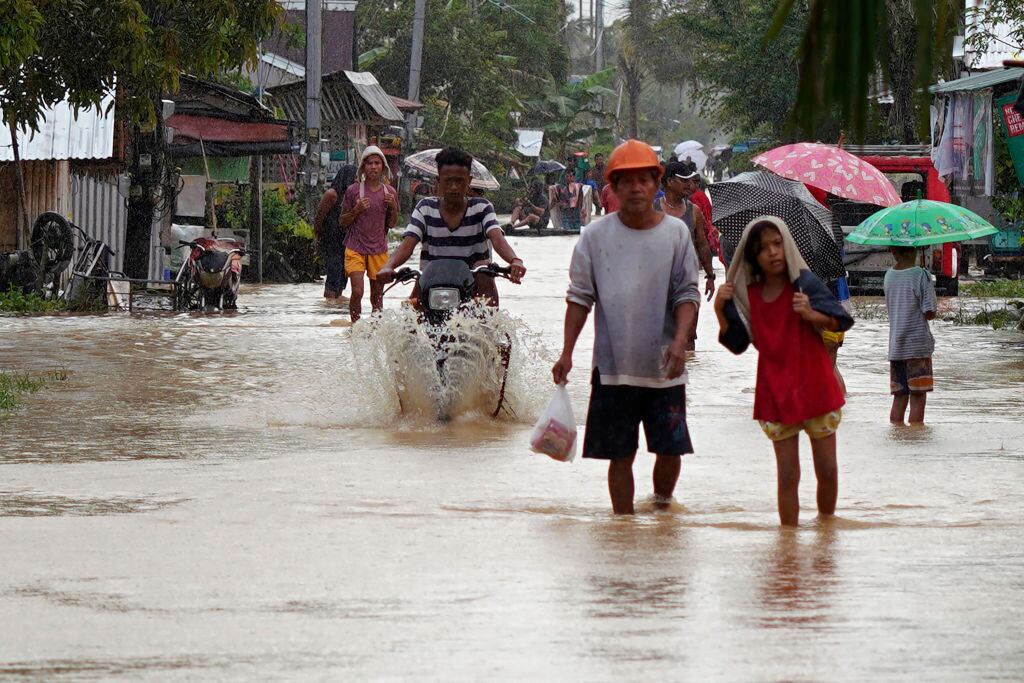 Residentes caminan por las calles inundadas de la ciudad de Abuyog