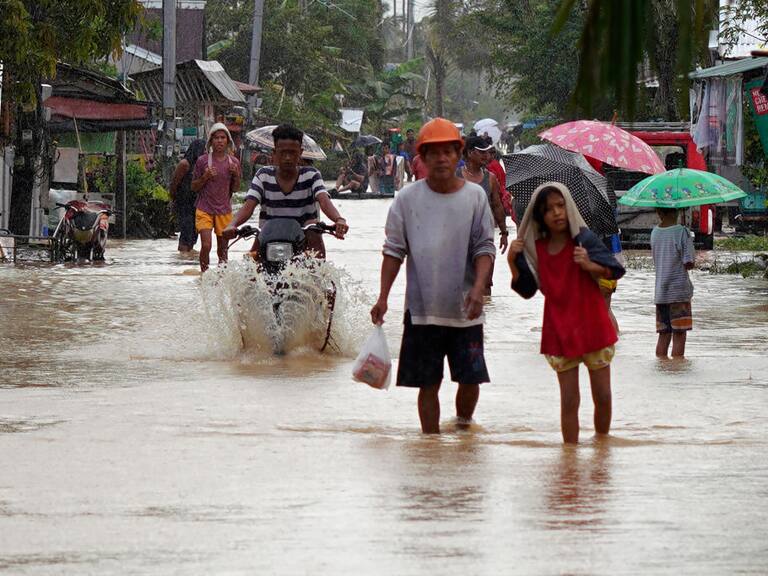 Residentes caminan por las calles inundadas de la ciudad de Abuyog