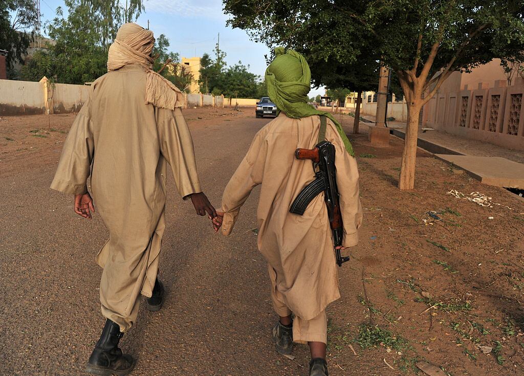 Dos paramilitares yihadistas transitan por una localidad africana