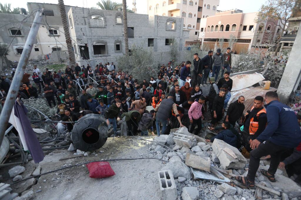 Personas buscan sobrevivientes tras un nuevo ataque aéreo de las fuerzas israelíes en contra del barrio Deir Al Balah en la Franja de Gaza.