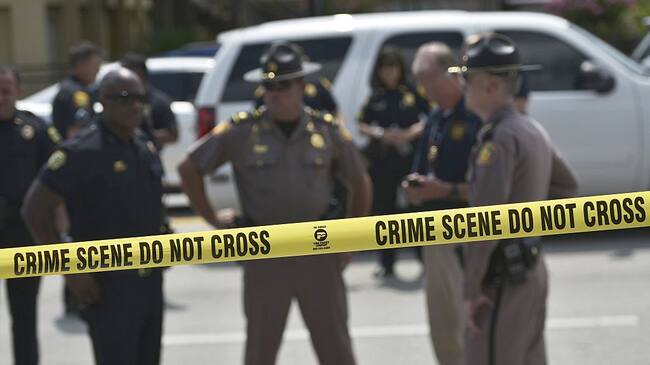 TOPSHOT - Police stand behind a crime scene tape near the mass shooting at the Pulse nightclub on in Orlando, Florida on June 12, 2016.A somber President Barack Obama expressed grief and outrage at the "horrific massacre" of 50 late-night revelers at an Orlando gay club, branding it an act of terror and hate. / AFP / Mandel Ngan (Photo credit should read MANDEL NGAN/AFP via Getty Images)