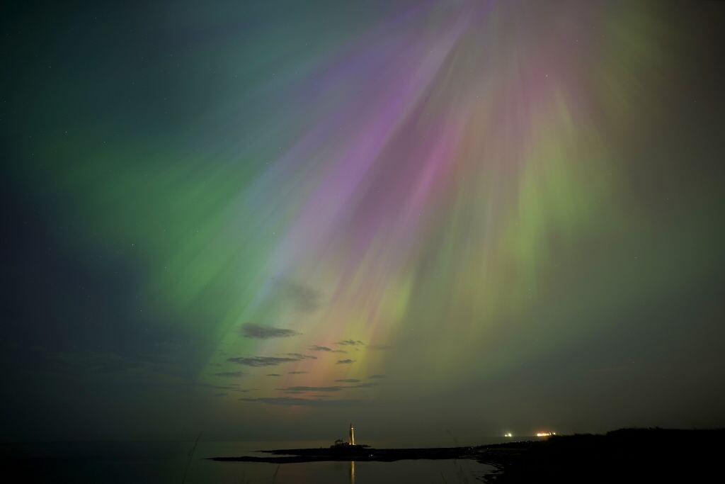 The aurora borealis, also known as the northern lights, glow on the horizon at St Mary's Lighthouse in Whitley Bay on the North East coast. Picture date: Friday May 10, 2024. (Photo by Owen Humphreys/PA Images via Getty Images)