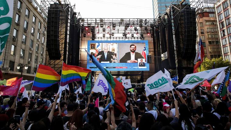 SANTIAGO, CHILE - DECEMBER 19: Supporters of Gabriel Boric president elect of Chile watch his videoconference with current president of Chile Sebastian Piñera after the presidential runoff election on December 19, 2021 in Santiago, Chile. (Photo by Marcelo Hernandez/Getty Images)