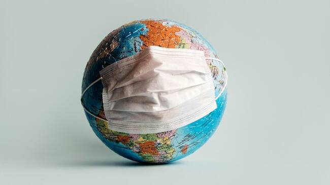 Globe made of jigsaw puzzles with a protective medical mask as a prophylaxis in the fight against coronavirus infection. Measures against the spread of the virus
