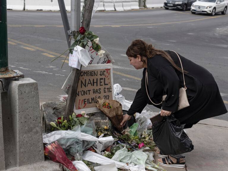 NANTERRE, FRANCE - JULY 1: A woman pays her respects at the site where Nahel M. died, shortly after his funeral, on July 1, 2023 in Nanterre, France. Nahel M., a French teenager of North African origin was shot dead by police on June 27th, the third fatal traffic stop shooting this year in France - causing nationwide unrest and clashes with police forces. (Photo by Sam Tarling/Getty Images)
