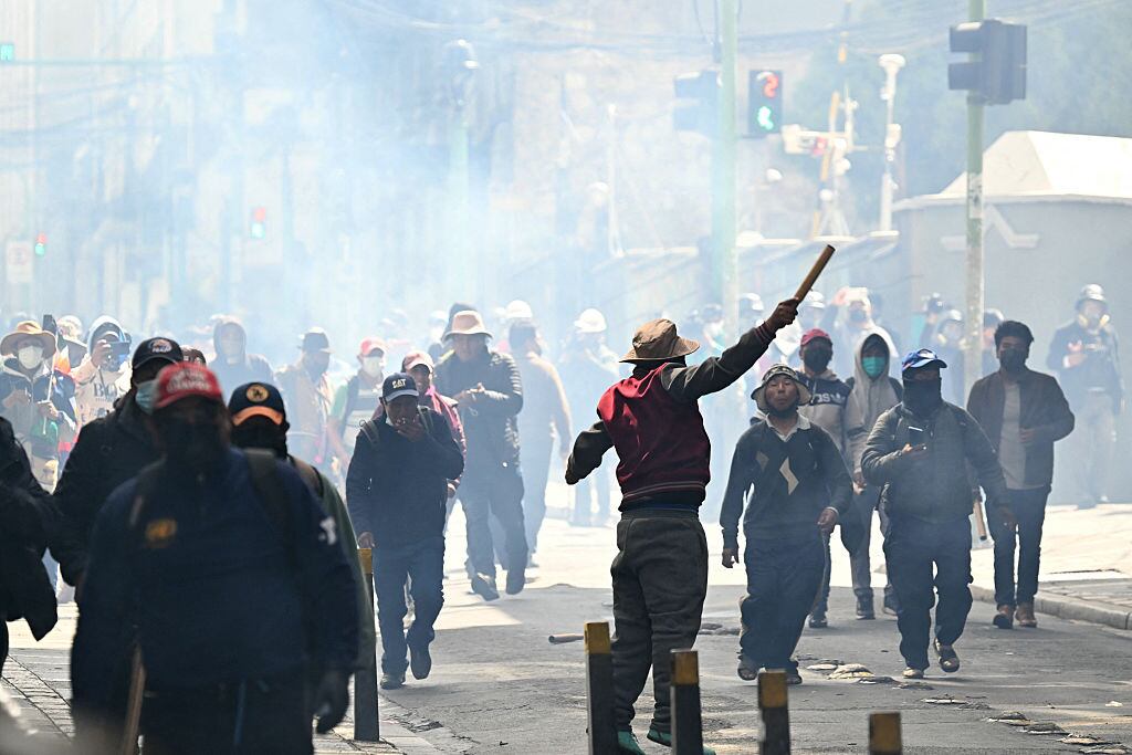 Protesters clash with riot police during a protest demanding the resignation of Bolivian President Rodrigo Paz, in La Paz, on May 18, 2026. Bolivians have taken to the streets for the past two weeks, blocking roads into La Paz and disrupting deliveries of food, medicine and other goods to the seat of government, while demanding higher wages, economic relief and the resignation of centre-right President Rodrigo Paz amid a severe economic crisis. (Photo by AIZAR RALDES / AFP via Getty Images)