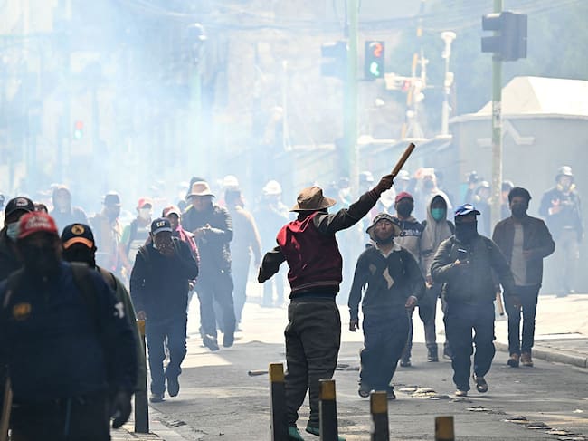 Protesters clash with riot police during a protest demanding the resignation of Bolivian President Rodrigo Paz, in La Paz, on May 18, 2026. Bolivians have taken to the streets for the past two weeks, blocking roads into La Paz and disrupting deliveries of food, medicine and other goods to the seat of government, while demanding higher wages, economic relief and the resignation of centre-right President Rodrigo Paz amid a severe economic crisis. (Photo by AIZAR RALDES / AFP via Getty Images)