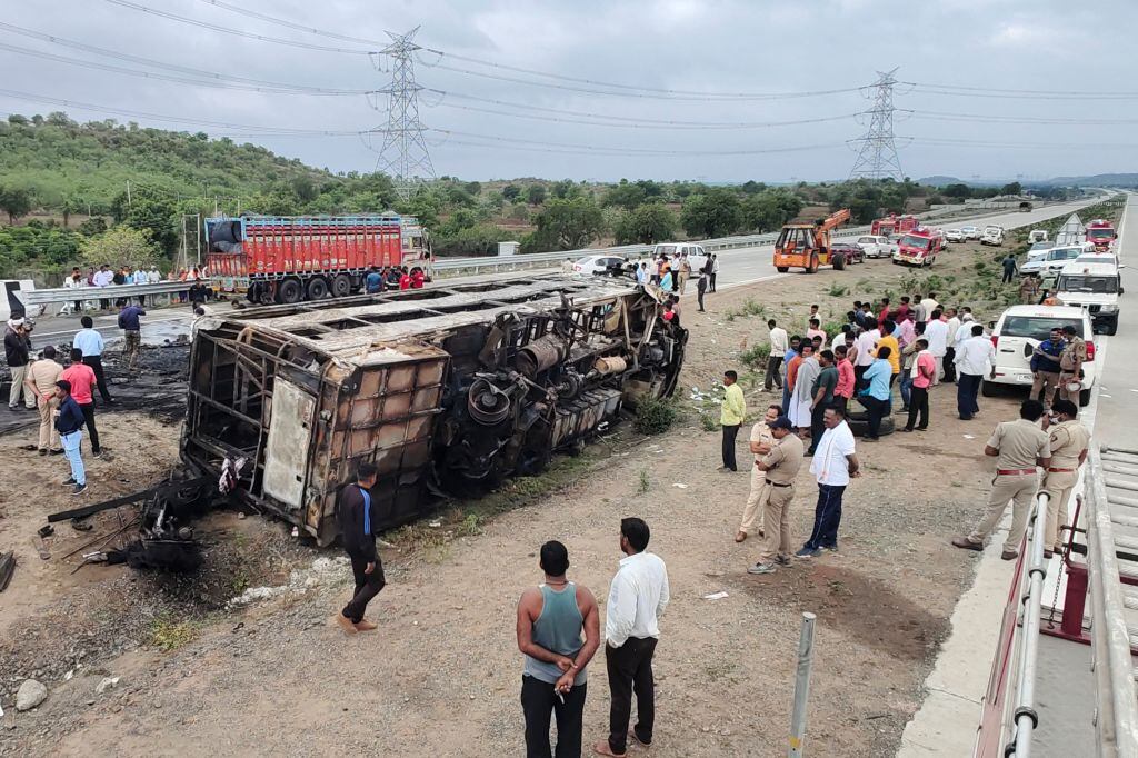 Personas observan el bus incendiado que deja muertos en India