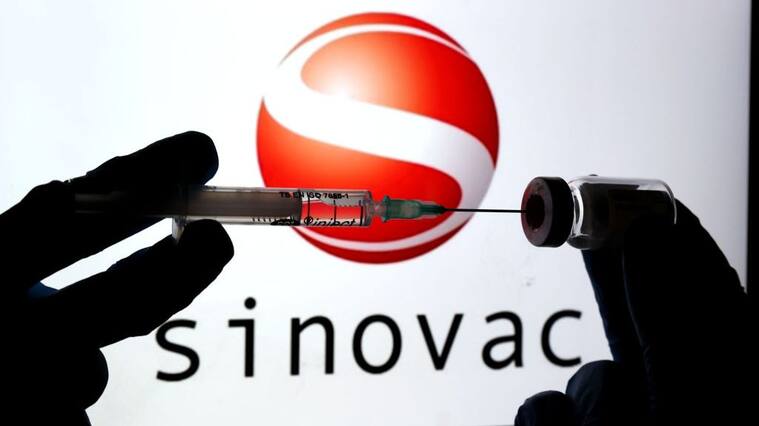 ANKARA, TURKEY - DECEMBER 16: In this photo illustration taken in Ankara, Turkey on December 16, 2020 Sinovac logo is displayed on a screen with a hand holdign a syringe in the front. (Photo by Mehmet Kaman/Anadolu Agency via Getty Images)