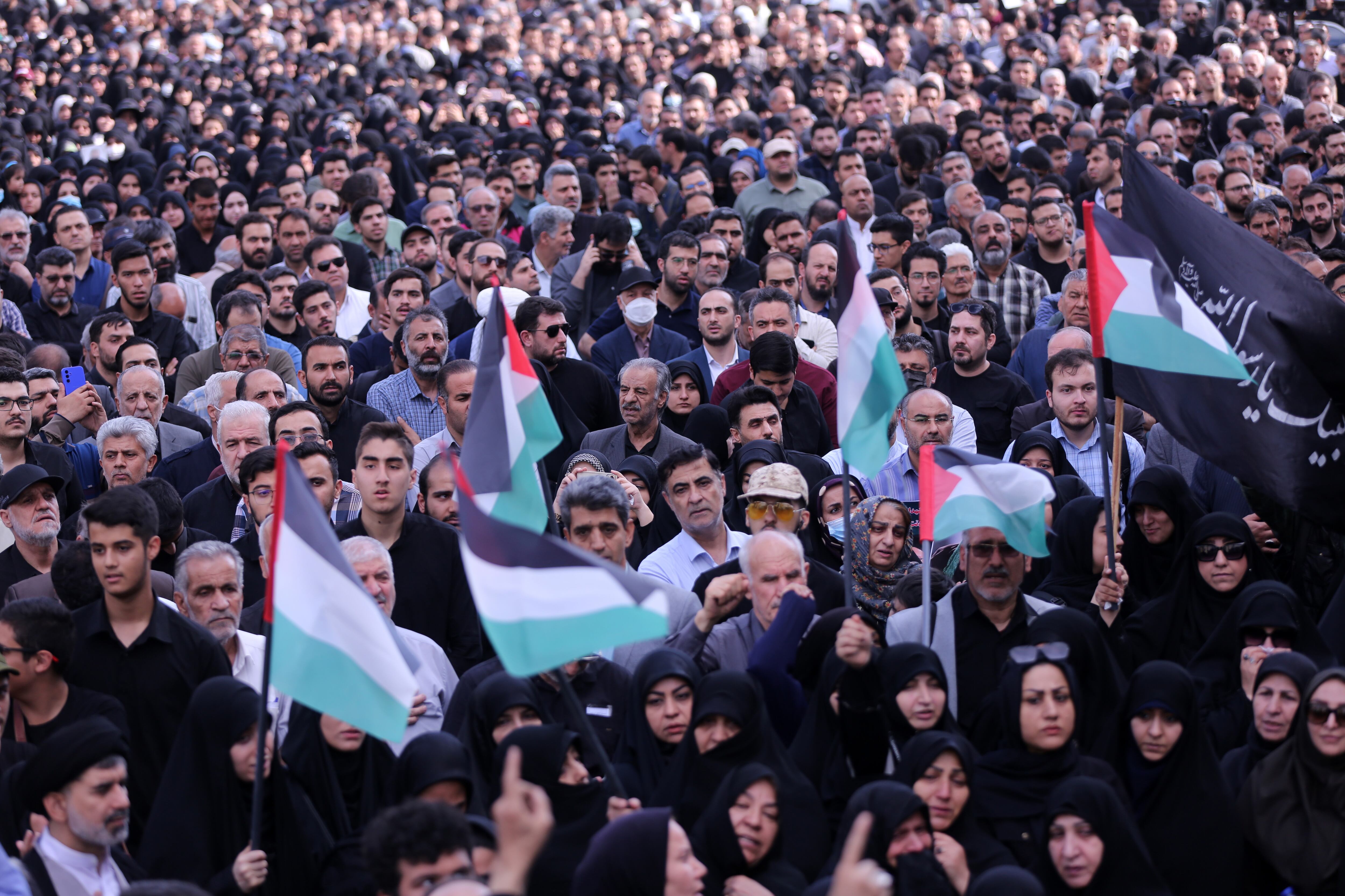 TEHRAN, IRAN - MAY 20: People holding photos gathering at Valiasr Square mourn the death of Iranian President Ebrahim Raisi, Foreign Minister Hussein Amir Abdollahian and other Iranian officials in a helicopter crash on Sunday in Iran, during a ceremony in Tehran on May 20, 2024. (Photo by Fatemeh Bahrami/Anadolu via Getty Images)