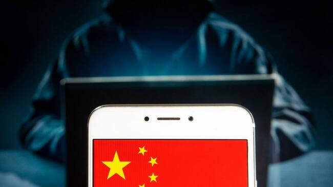 HONG KONG - 2019/04/05: In this photo illustration a People's Republic of China flag is seen on an Android mobile device with a figure of hacker in the background. (Photo Illustration by Budrul Chukrut/SOPA Images/LightRocket via Getty Images)