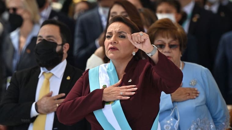 Honduran president-elect Xiomara Castro holds up her clenched fist as she wears the presidential sash after swearing in during her inauguration ceremony, in Tegucigalpa, on January 27, 2022. - Honduras president-elect Xiomara Castro swore in as the country's first woman president on Thursday, as confusion reigns over who will be head of congress during her four-year term. (Photo by Luis Acosta / AFP) (Photo by LUIS ACOSTA/AFP via Getty Images)